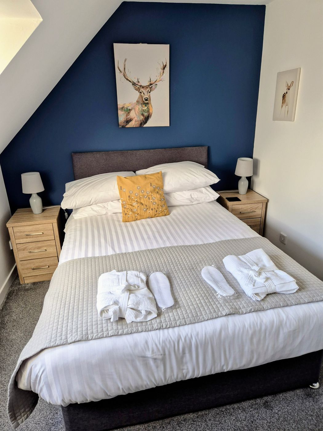 Redecorated bedroom with a deep blue feature wall and freshly painted white ceiling and walls